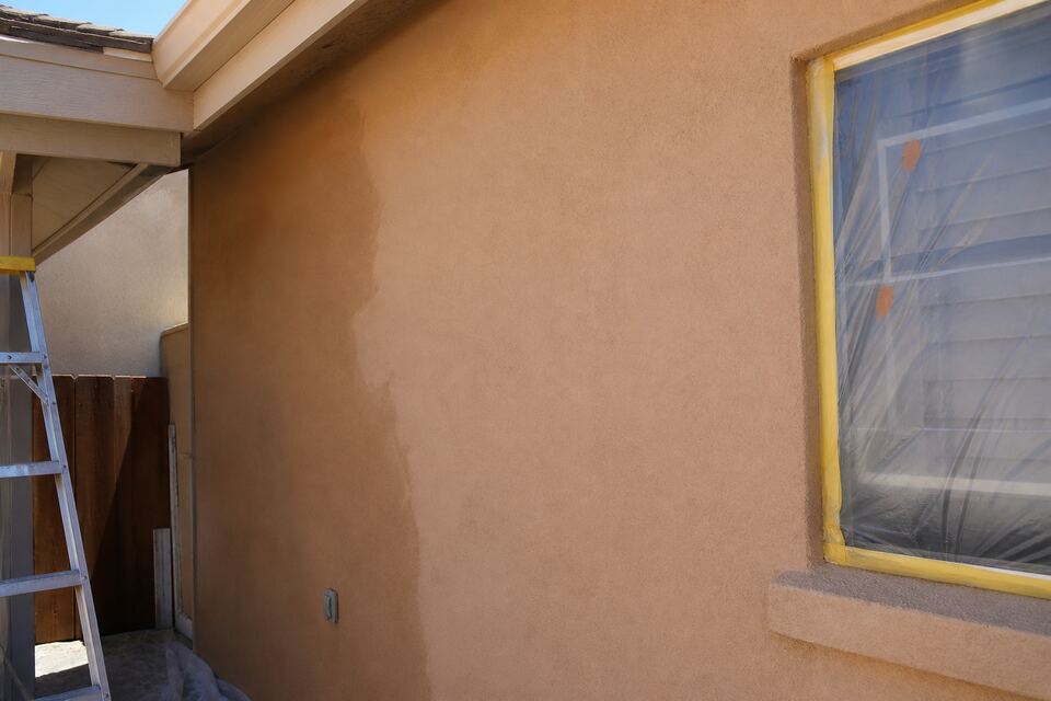 Freshly color-coated stucco wall in warm earth tone drying in Santa Fe sun